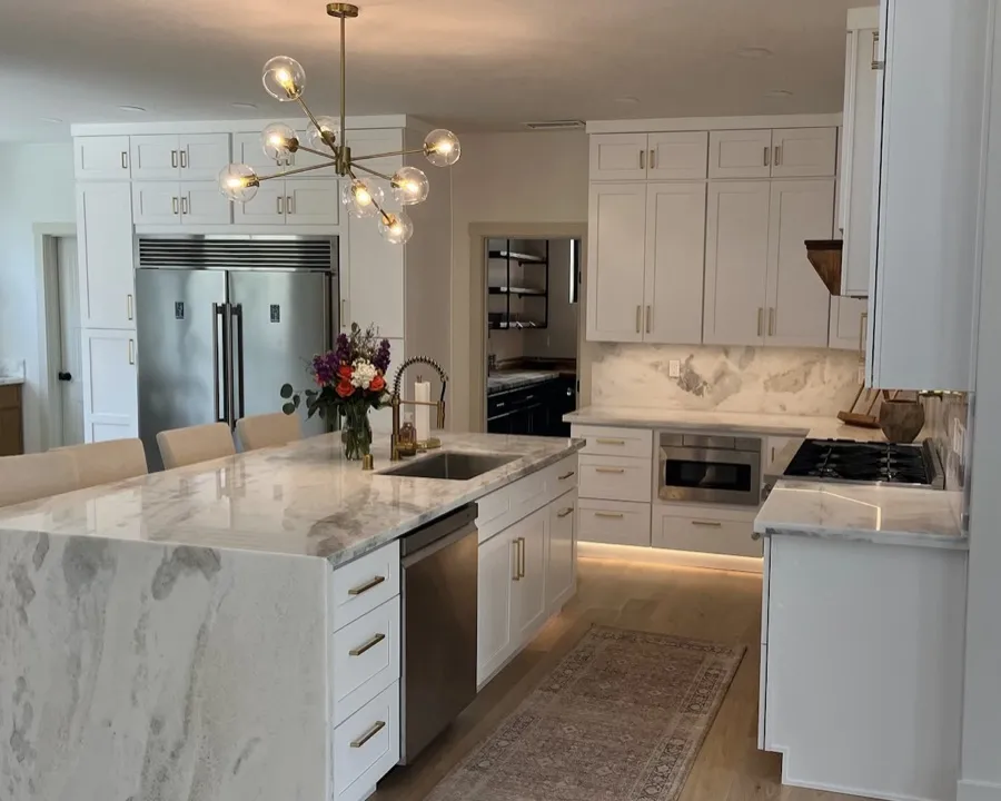 White pre-made shaker cabinets with marble waterfall island