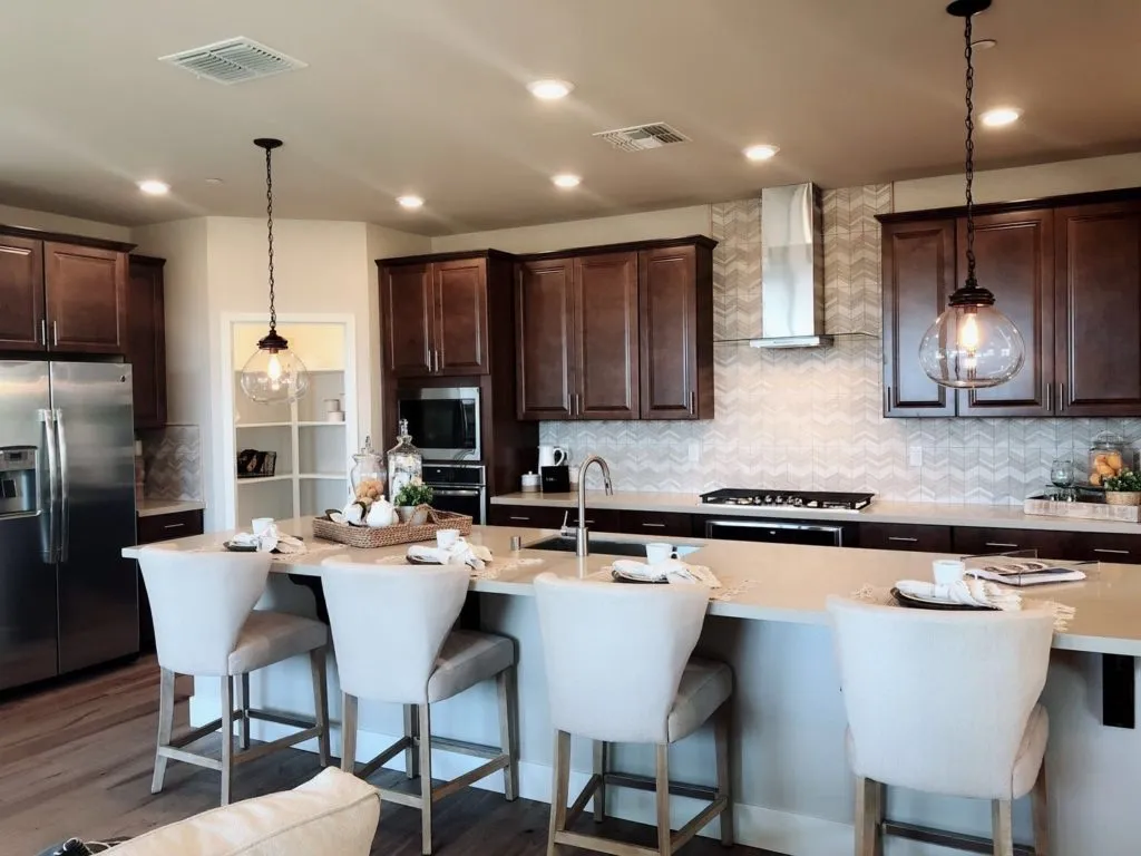 Dark wood kitchen with white island seating and chevron tile